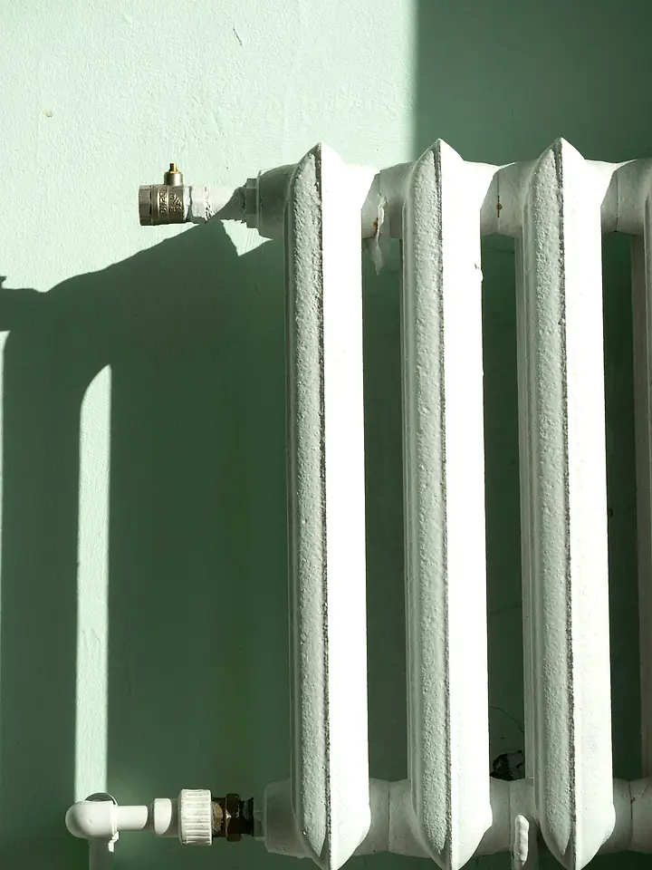 Weißer Gussheizkörper an einer sonnigen Wand