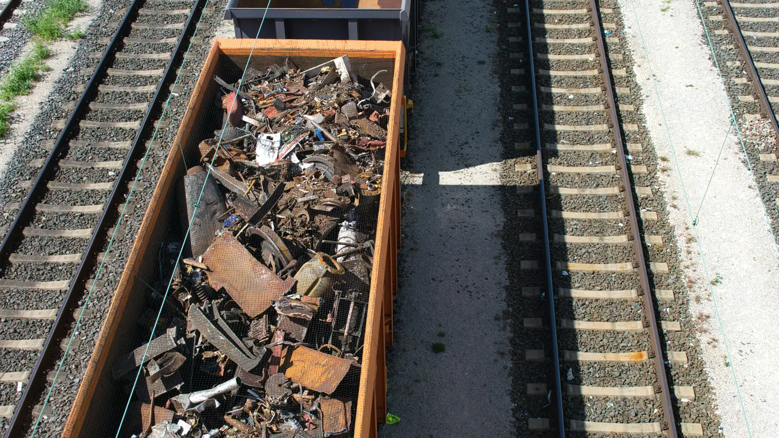 Offener Güterwagen voller Stahlschrott auf Gleisen, von oben gesehen